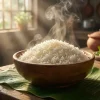 Bát cơm trắng nấu từ gạo Thơm Mỹ hạt dài, nở xốp và mềm cơm, bốc hơi nóng hổi trong ánh nắng sớm, đặt trên lá chuối xanh.
